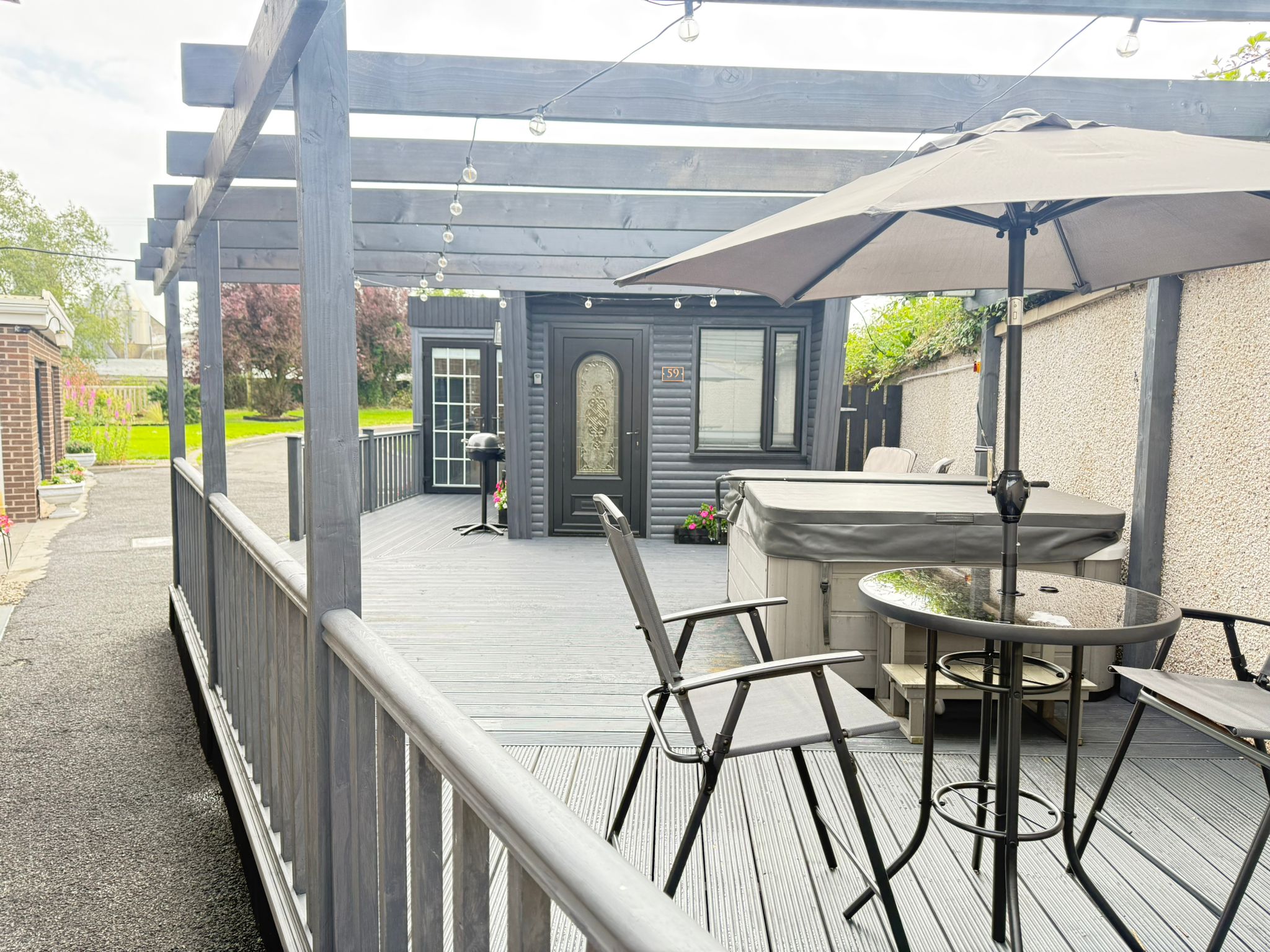 Private hot tub, pergola with string lights and outdoor dining on the deck